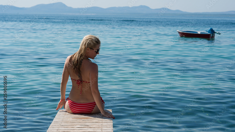 Beautiful Girl on The Pier. Ocean. Vacation. Mallorca island in a beautiful summer day. Beautiful beach landscape with woman on the pier. Beautiful Girl on The Pier. Ocean. Vacation. Mallorca island in a beautiful summer day. Beautiful beach landscape with woman on the pier.