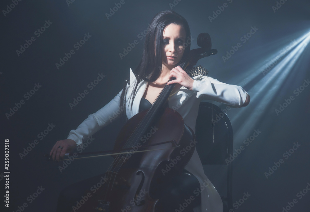 Beautiful woman in a white coat plays the cello Beautiful woman in a white coat plays the cello