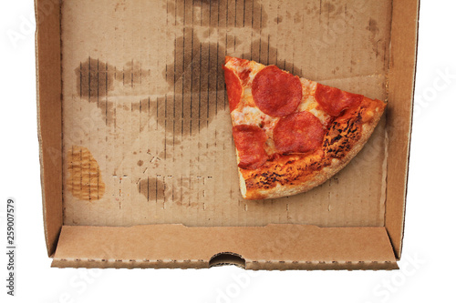 Leftover pepperoni pizza slice in delivery box top view. Last slice of original italian fresh pepperoni pizza in paper box from take out