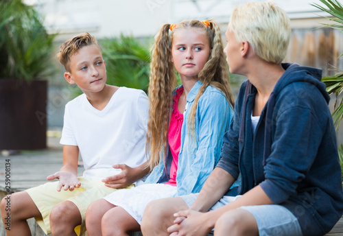 Smiling girl with boys discussing outdoors