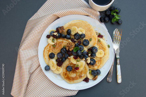 Freshmade, homemade pancakes with blueberry, dried fruits and honey. Breakfast with coffee and pancakes. Deliciious healthy food. photo