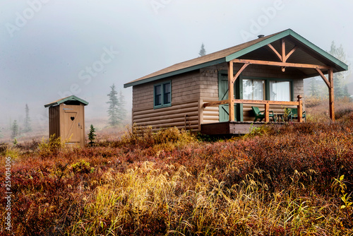 A little cabin in Alaska with an outside bathroom.