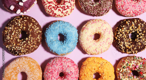 assorted donuts with chocolate frosted, pink glazed and sprinkles donuts.