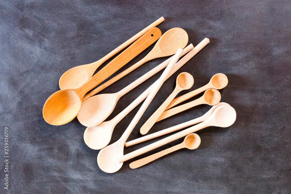 Wooden spoons on blackboard background.
