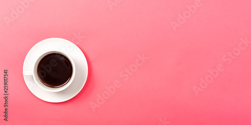 A coffee cup on a pink paper background