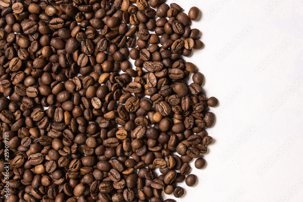 Roasted coffee beans in bulk on a light blue background. dark cofee roasted grain flavor aroma cafe, natural coffe shop background, top view from above, copy space Roasted coffee beans in bulk on a light blue background. dark cofee roasted grain flavor aroma cafe, natural coffe shop background, top view from above, copy space