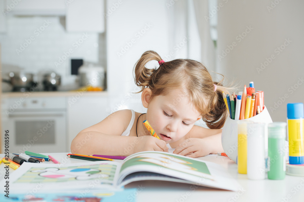 Cute little girl is drawing with felt-tip pen at home