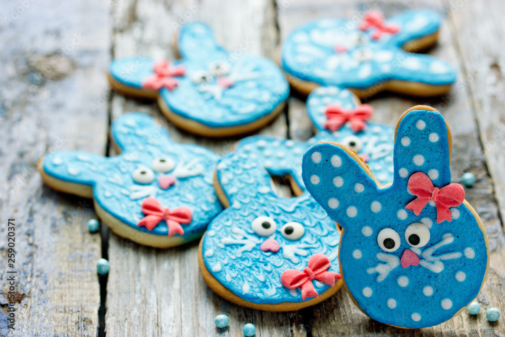 Funny bunny cookies, homemade gingerbread biscuits shaped rabbits in blue glaze for Easter