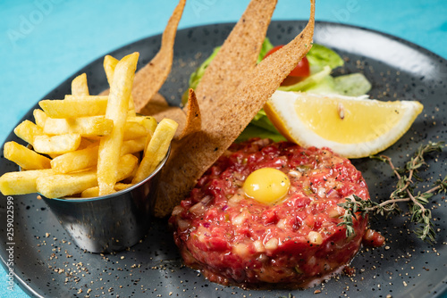 Beef tartare with egg yolk and french fries photo