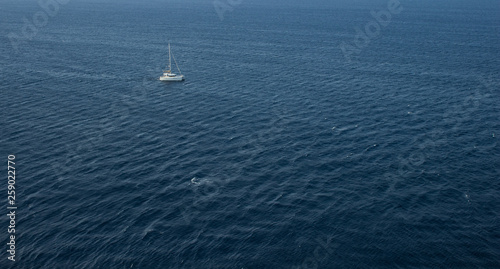 simple scenery landscape pattern summer cruise vacation concept of single walking yacht in water environment in Mediterranean sea not far from Greece coast line, copy space in aerial photography