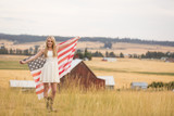 Energetic young woman holding flag in countryside