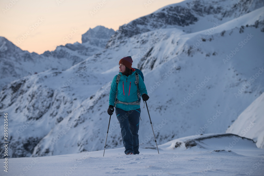 Female hiker in winter mountain landscape, Ytresandheia, Moskenesøy, Lofoten Islands, Norway Female hiker in winter mountain landscape, Ytresandheia, Moskenesøy, Lofoten Islands, Norway