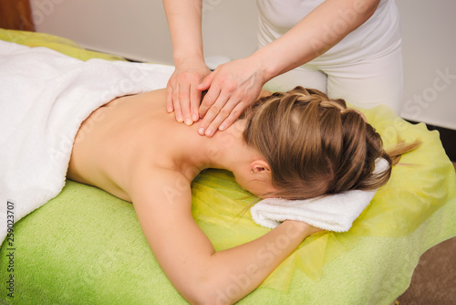 Woman having neck and shoulder massage in spa center