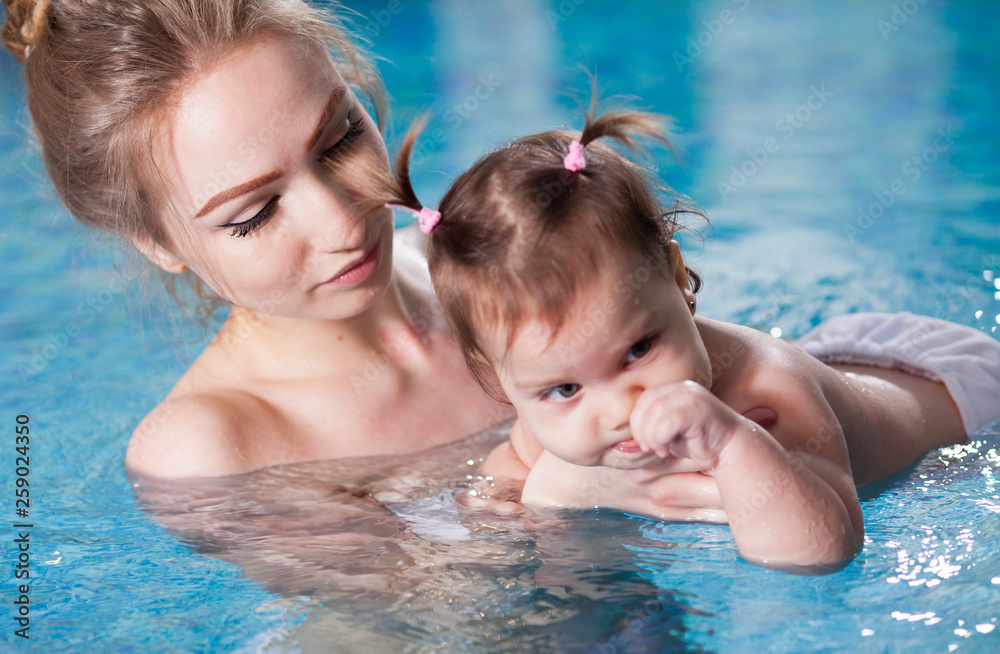 young mother bathes the baby in the pool. young mother bathes the baby in the pool.