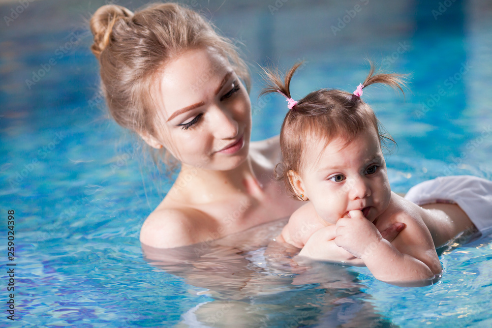 young mother bathes the baby in the pool. young mother bathes the baby in the pool.