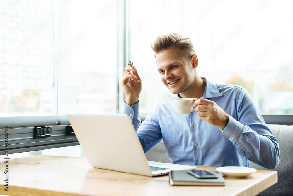 Young businessman working on a plan of Internet project on the laptop. Man discusses business matters by phone. Working computer for internet research. Digital marketing. Development Young businessman working on a plan of Internet project on the laptop. Man discusses business matters by phone. Working computer for internet research. Digital marketing. Development