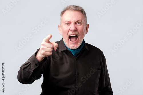 Foto Angry man screaming, pointing index finger at you.