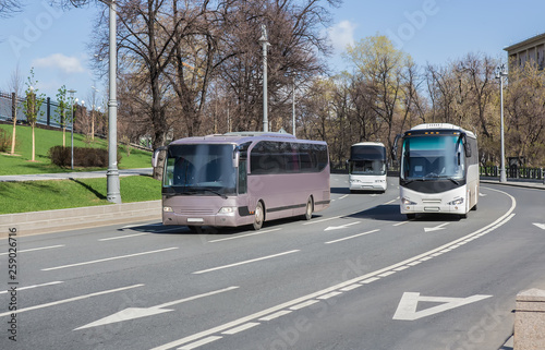 Tourist buses move along the street