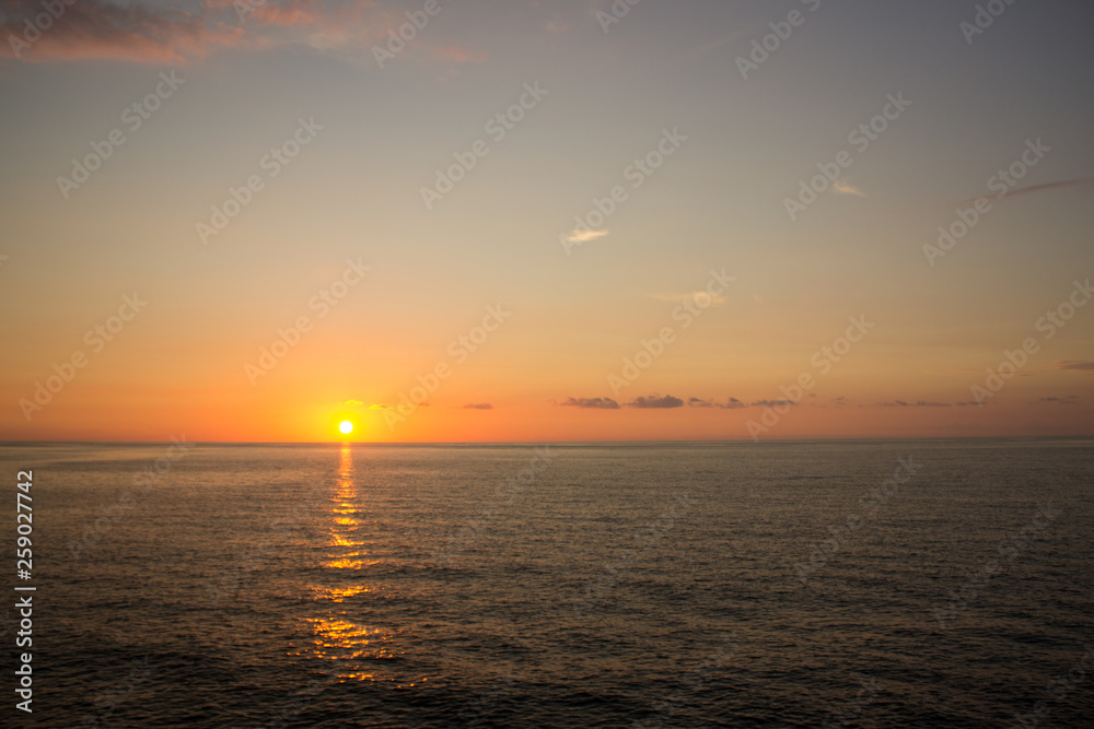 calming peaceful horizontal scenic sunset landscape with sun orange light above water surface and empty copy space for text