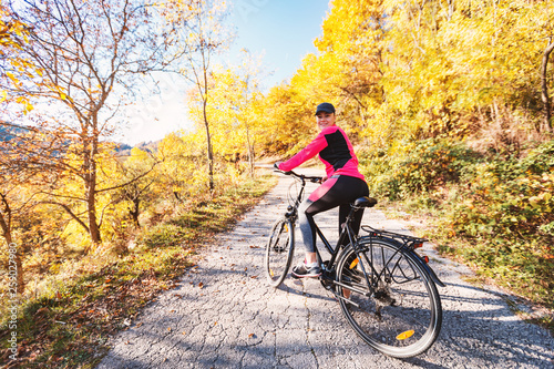 Woman on bicycle at autumn day wearing sportswear