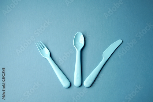 Blue plastic dishes on blue background. Concept