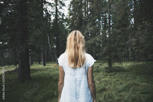 White dressed woman, alone in magic forest.