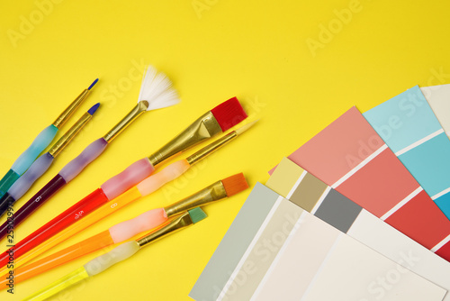 Brushes and palette on yellow background