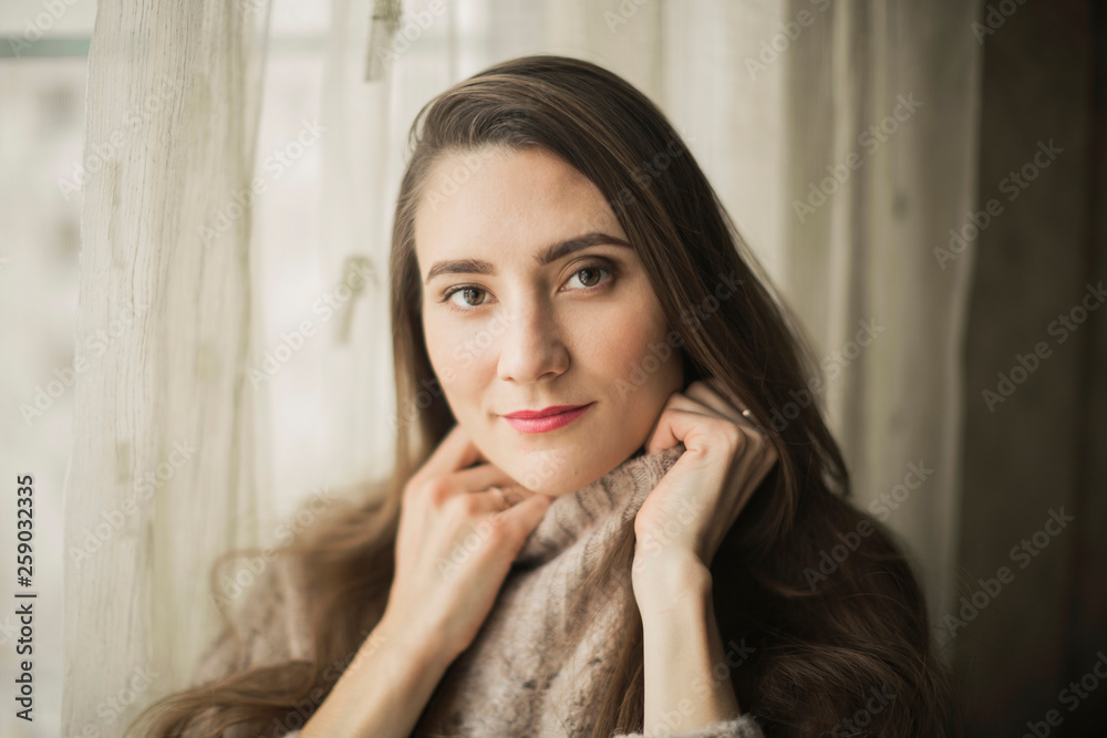 portrait of a young woman girl with bright lips in a warm sweater