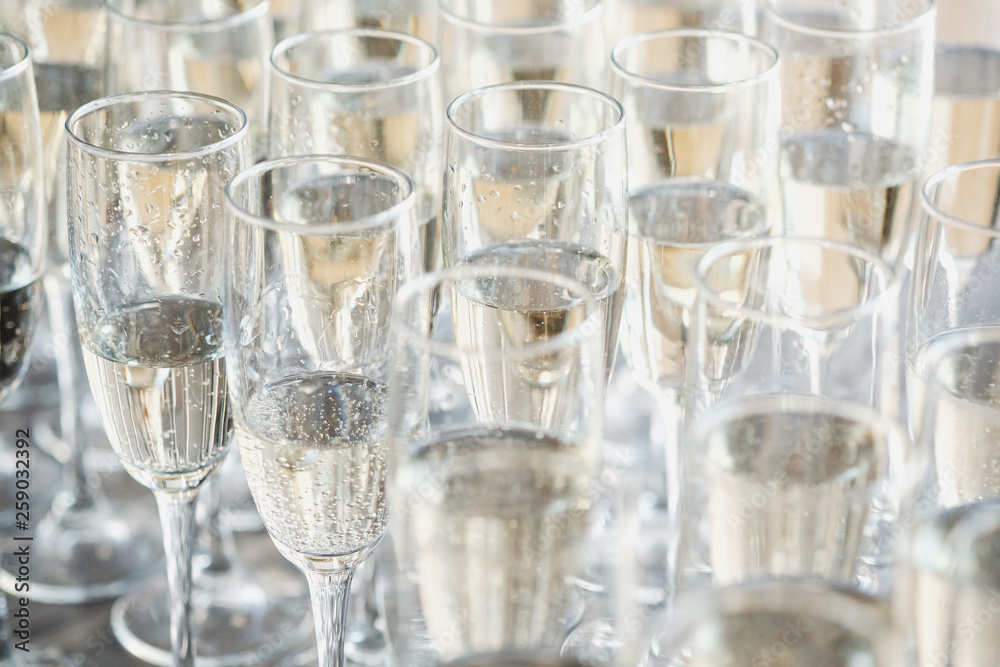 A row of glasses of champagne on a light background. Buffet concept and event organization. A row of glasses of champagne on a light background. Buffet concept and event organization.