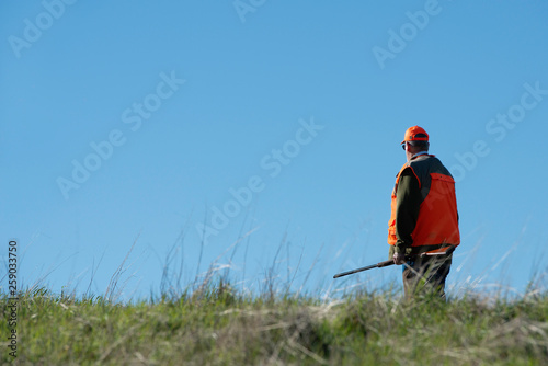 Upland bird hunter against a blue sky.