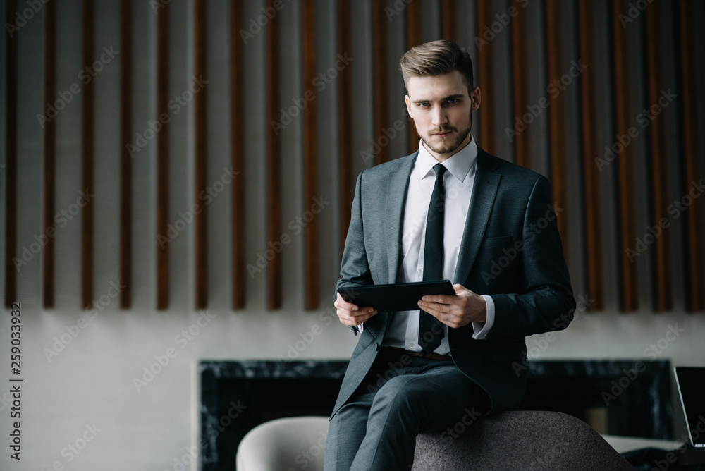 Fototapeta premium Young man drawing template for the web site associated with digital marketing, current trends and tendencies of UX / UI design. Businessman who rules his company remotely, like a freelancer