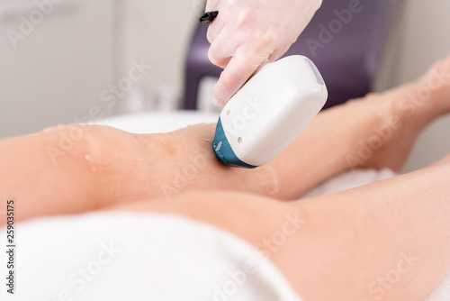 Laser epilation and cosmetology. Hair removal on ladies legs. at cosmetic beauty spa clinic. Cosmetology procedure from a therapist