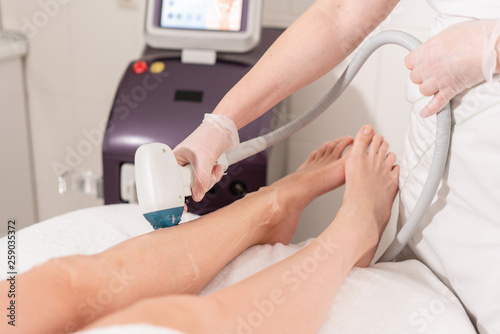 Laser epilation and cosmetology. Hair removal on ladies legs. at cosmetic beauty spa clinic. Cosmetology procedure from a therapist