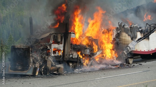 A semi truck burns out of control on a highway photo