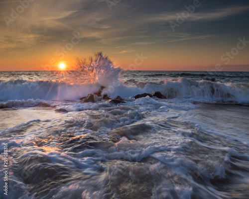 Ocean sunrise with waves crashing on the rocks at the shore in Ocean City, MD. Photo by: Chuck Beyer