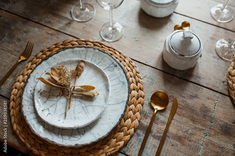 White plate and golden fork with a spoon, appliances for frying, wedding decoration. Christmas or tanksgiving dinner. From above White plate and golden fork with a spoon, appliances for frying, wedding decoration. Christmas or tanksgiving dinner. From above