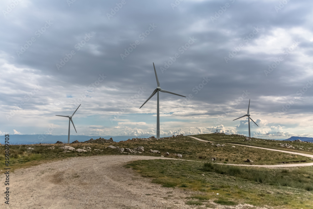 View of a wind turbines on top of mountains View of a wind turbines on top of mountains