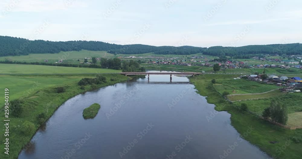 Aerial view of the river and green mountains around. Drone video of river between green hills and mountains. Ural mountains, Bashkiriya, Russia. Aerial view of the river and green mountains around. Drone video of river between green hills and mountains. Ural mountains, Bashkiriya, Russia.