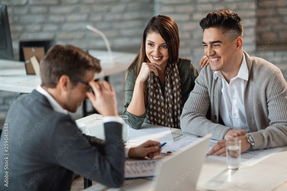 Cheerful couple talking with financial advisor on a meeting in the office. Cheerful couple talking with financial advisor on a meeting in the office.