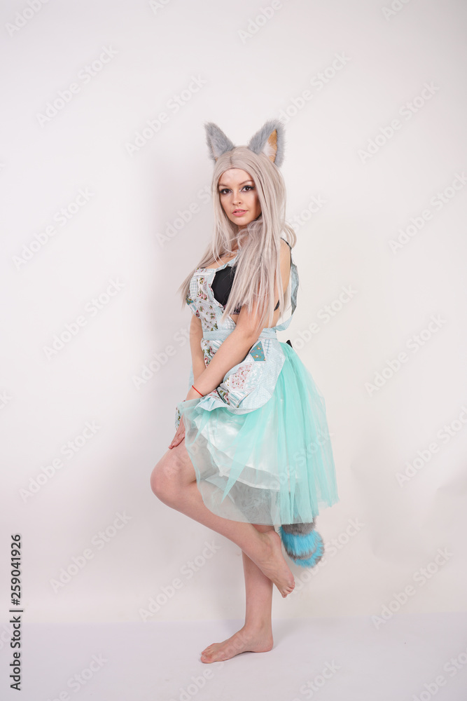 pretty playful young girl with cat ears and long fluffy fur tail wearing kitchen apron on white background isolated pretty playful young girl with cat ears and long fluffy fur tail wearing kitchen apron on white background isolated