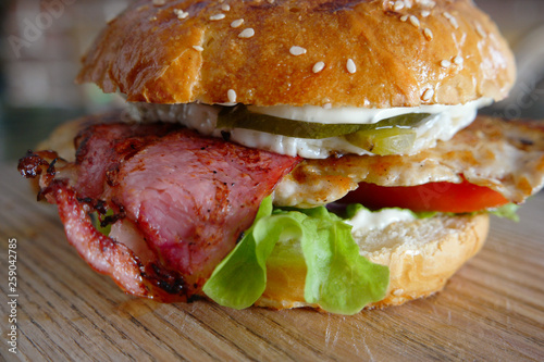 Closeup of Grilled Burger with salad and backon on cutting board photo