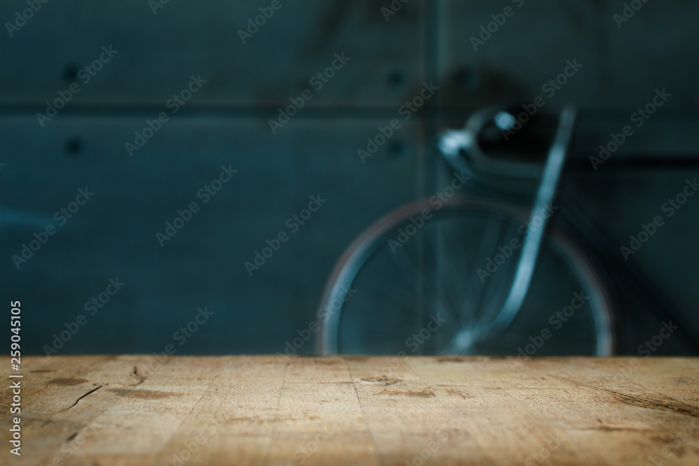 Empty Wooden Table in Front of Blurred Background of Living Room with a Blue Bicycle Near the Window. Mock Up for Display of Product. Blank for Your Layout Empty Wooden Table in Front of Blurred Background of Living Room with a Blue Bicycle Near the Window. Mock Up for Display of Product. Blank for Your Layout