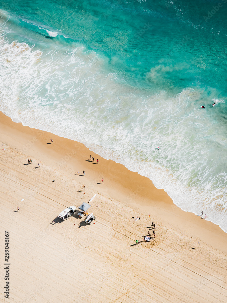 Obraz premium Ocean aerial landscape of surfer waiting for waves at sunrise with a beautiful light.