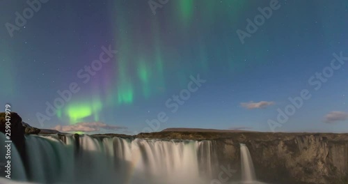 Timelapse of amazing northern lights over waterfall in Iceland