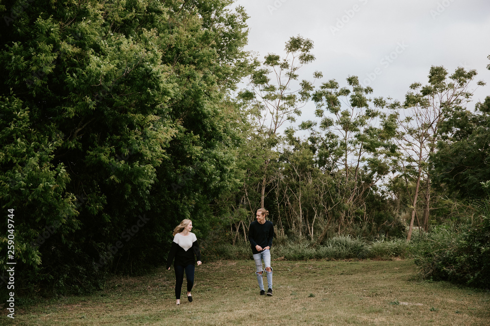 Cute Young Attractive Dating Couple Looking, Smiling, and Laughing in the Dense Isolated Green Tropical Forest Jungle Cute Young Attractive Dating Couple Looking, Smiling, and Laughing in the Dense Isolated Green Tropical Forest Jungle