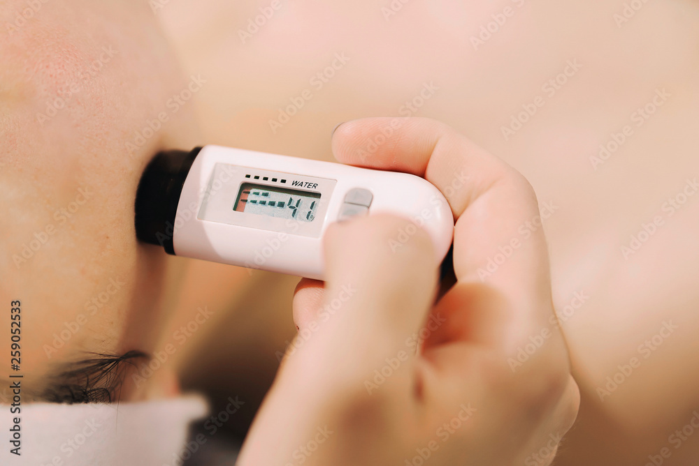 A device for measuring skin moisture saturation. Measurement of skin moisture in cosmetology. - obrazy, fototapety, plakaty 