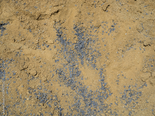 Closeup of a pile of sand and stones in construction site , brown sand and gray stones background.
