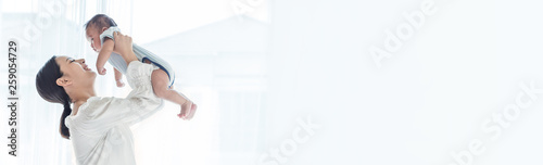 Photography Mother lifting and playing with newborn baby, baby talking to mother