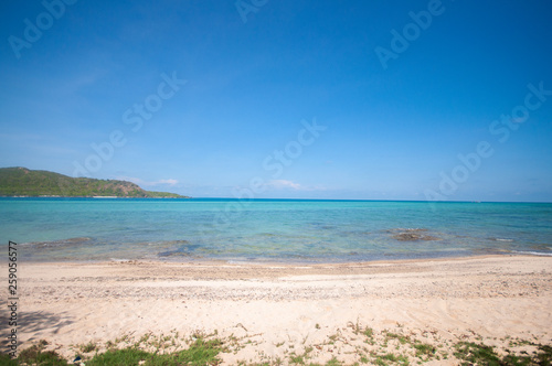 Landscape of beautiful blue sky sea and sand with green mountain is background some morning glory on the beach