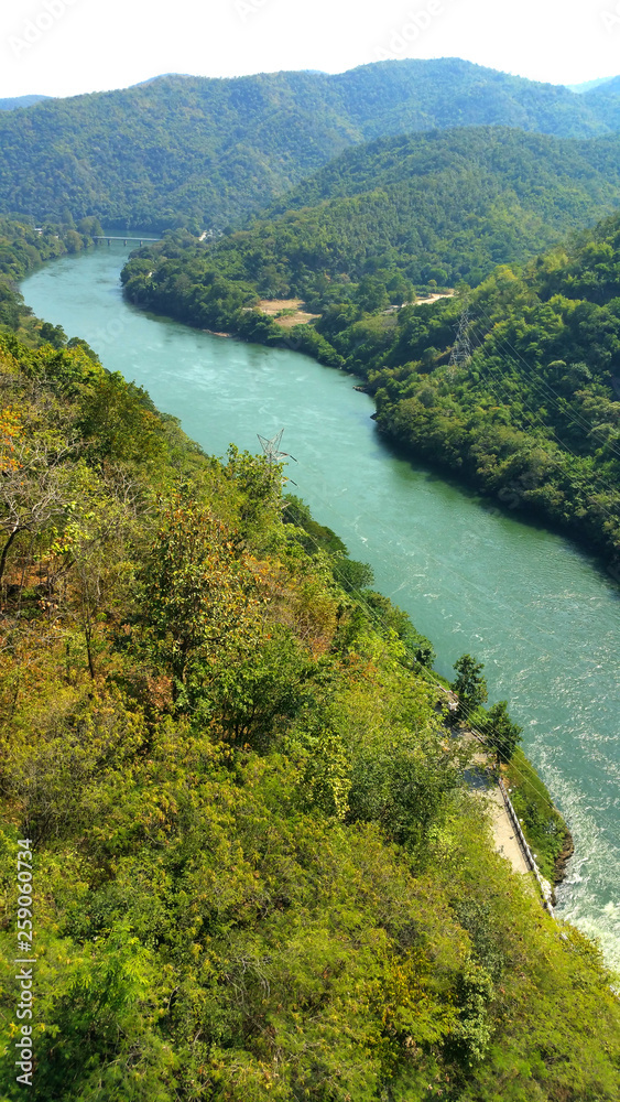 The river's water flows from the Bhumibol dam and surrounding mountains the trees green